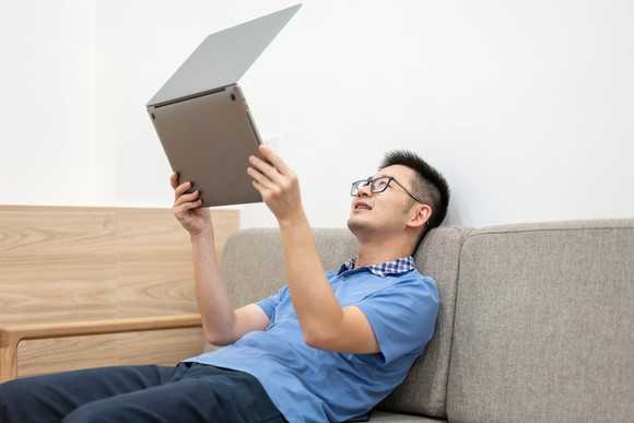 Person staring intently at a laptop.