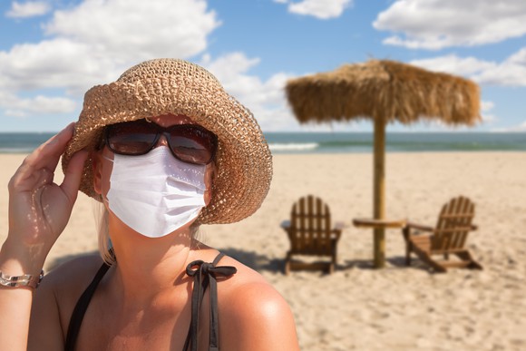 Person on a beach wearing a mask. 
