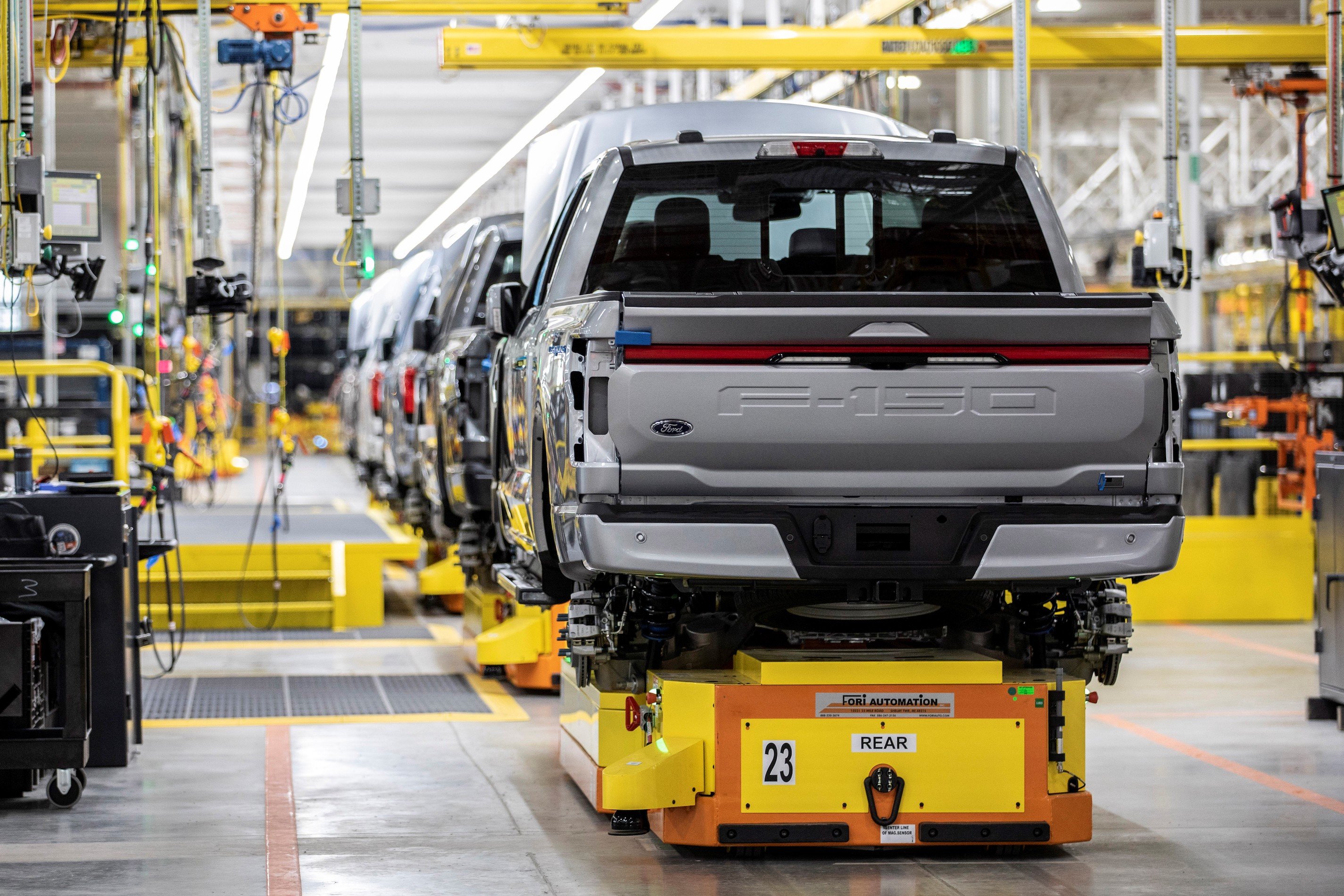 Partially-assembled Ford F-150 Lightnings on a factory assembly line. 