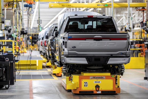 Partially-assembled Ford F-150 Lightnings on a factory assembly line. 