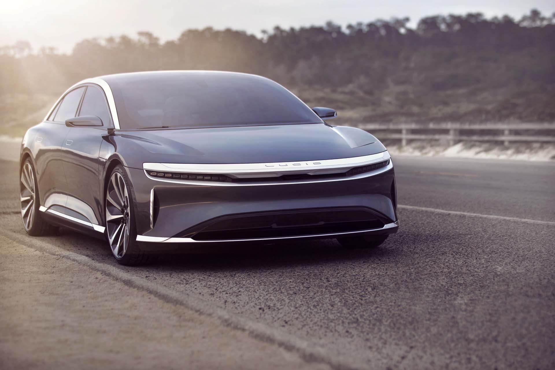 Blue Lucid Air electric sedan on roadway. 