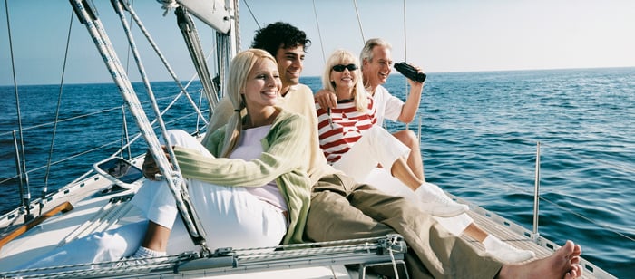 Four people on a sailboat at sea.