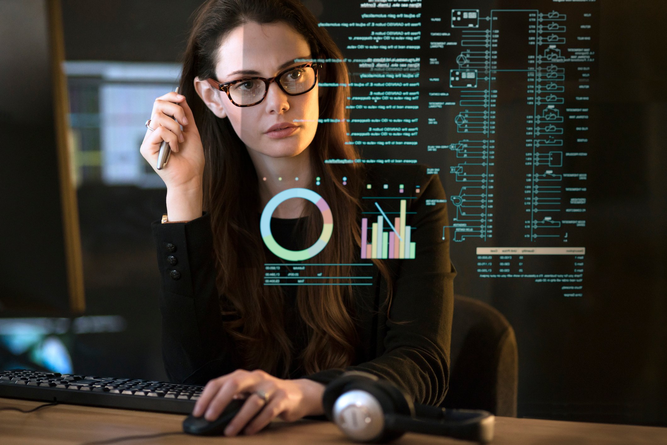 Person analyzing data on a computer at a desk.