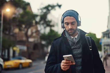 man headphones phone city street Getty Images