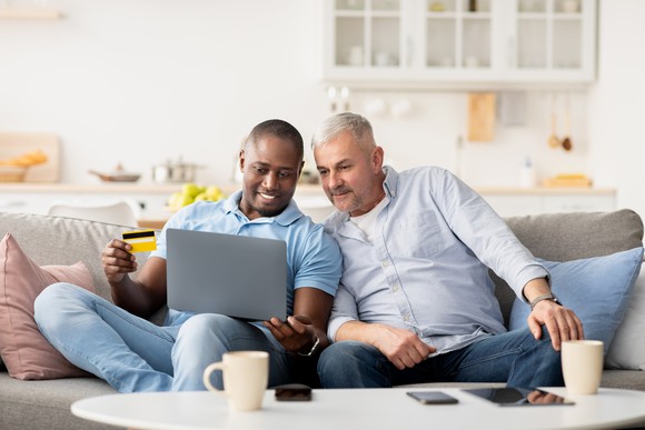 Two people shop online on a laptop.