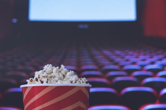 A bucket of popcorn sitting in a movie theater.