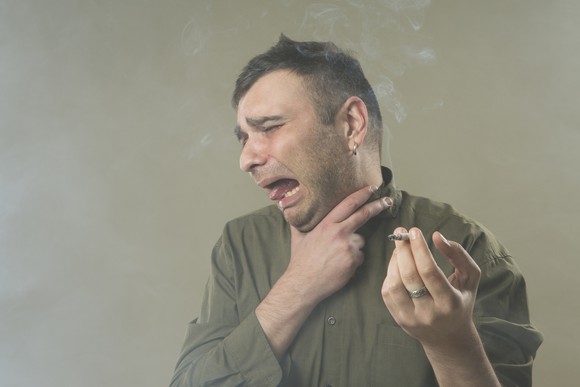Man choking on marijuana cigarette