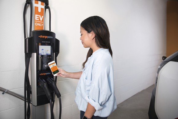 EV driving using ChargePoint app at charger in parking space.