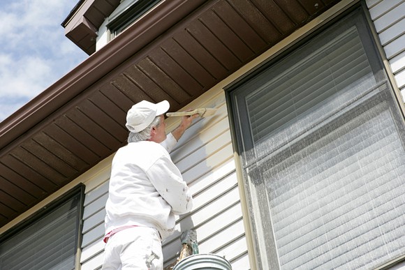 A house painter works on a house.