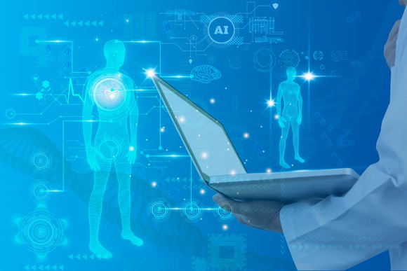 Digital images of the human body and various charts, next to an arm of a person holding a laptop.