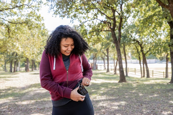 A hiker checks on the readings of an insulin pump.