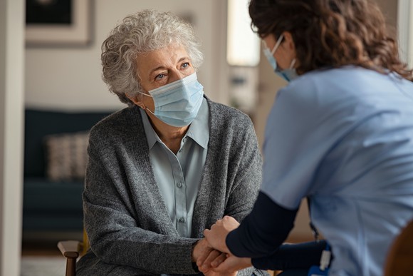 Two people talking together wearing masks. 