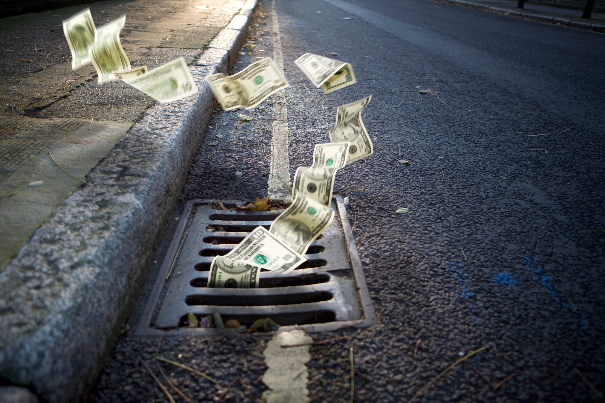 Money going down a manhole.