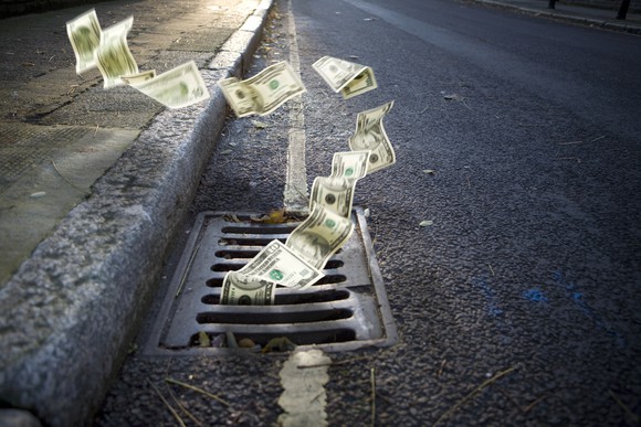 Money going down a manhole.