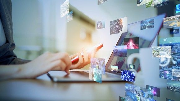 Laptop open with digital images displayed. 