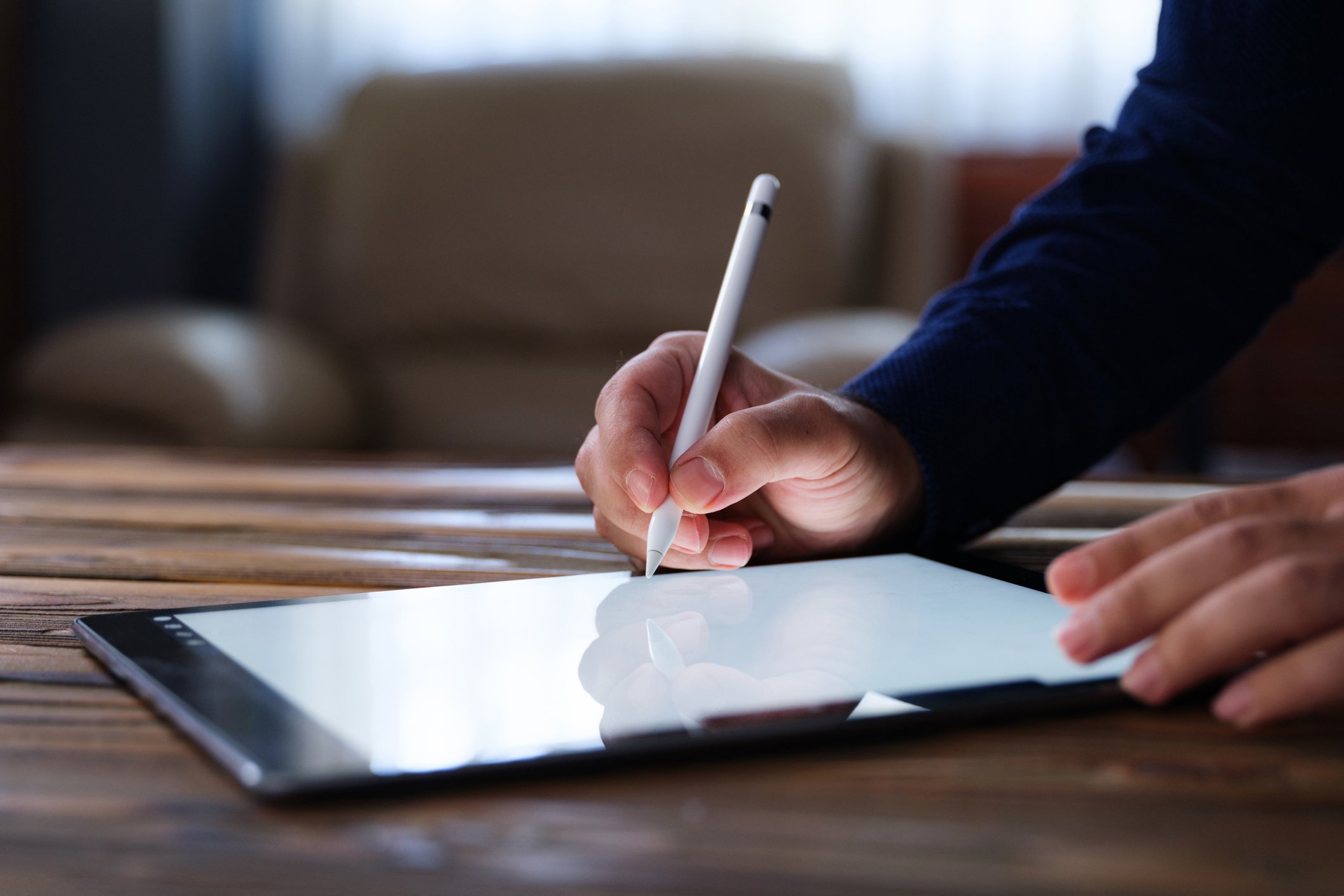 A business person signing a digital document on a tablet.