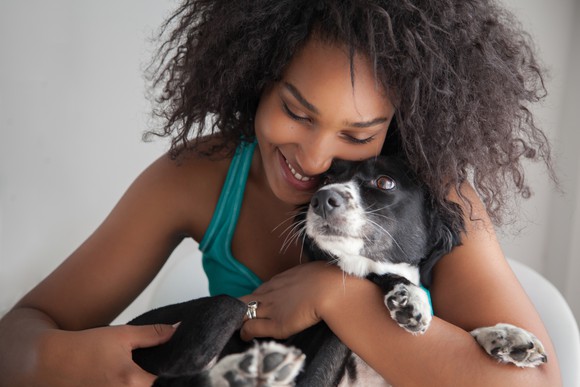 A dog rests comfortably in a caretaker's arms.