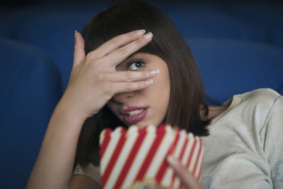 Person at movie theater scared to watch.
