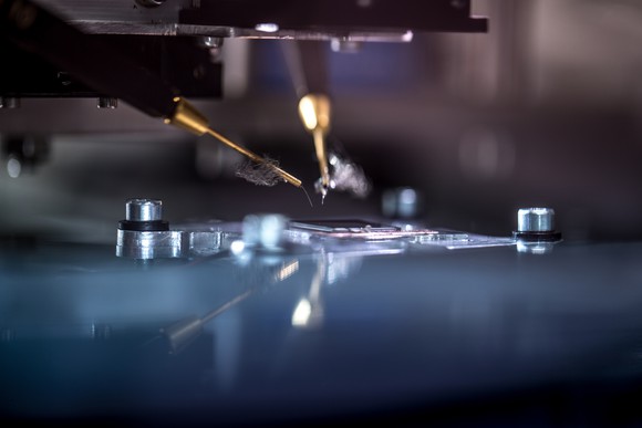 Machines etching a semiconductor on a silicon wafer. 