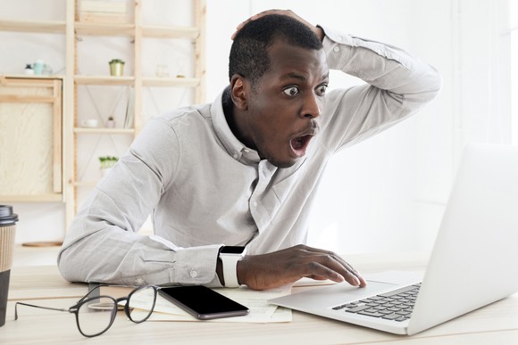 Person in complete shock looking at something on laptop screen