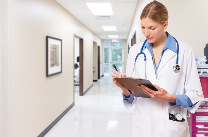 Physician writing on a clipboard. 