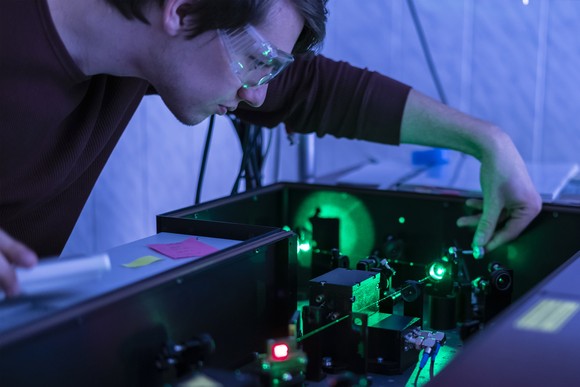 Someone using lasers to conduct a quantum mechanics experiment.
