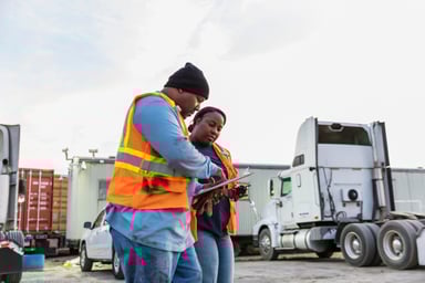 two supply chain workers sign paperwork
