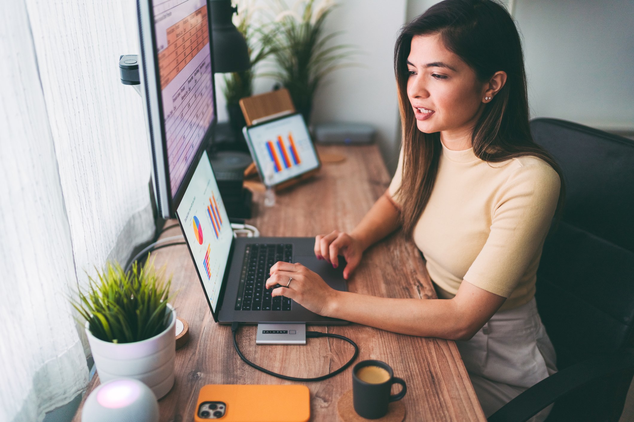 An entrepreneur reviewing financial charts on an ecosystem of digital devices.