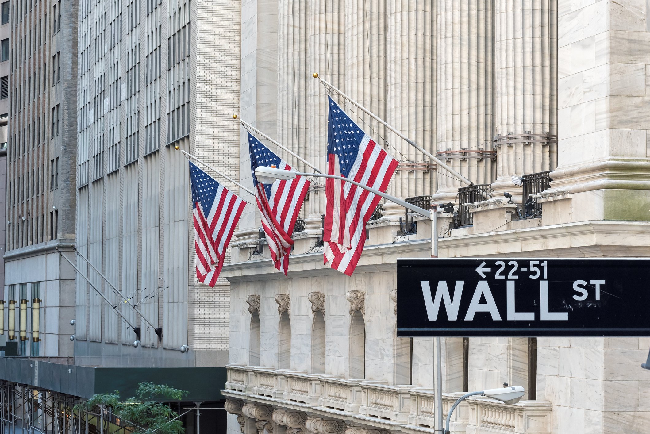 View of Wall Street sign with buildings. 