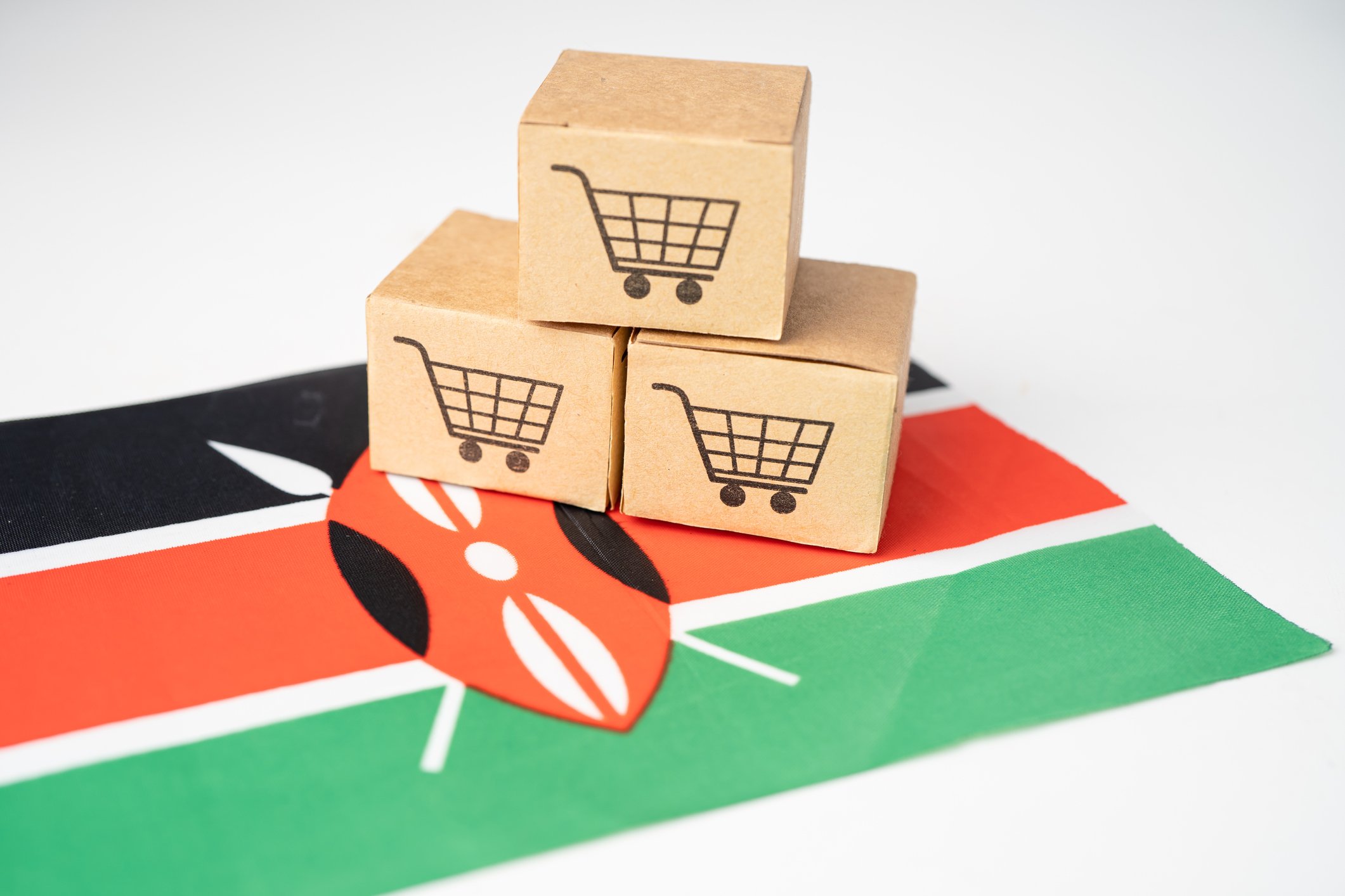 Miniature e-commerce shopping boxes on Kenyan flag.
