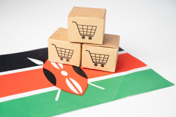 Miniature e-commerce shopping boxes on Kenyan flag.