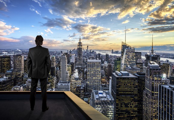 A person looking at towering skyscrapers.