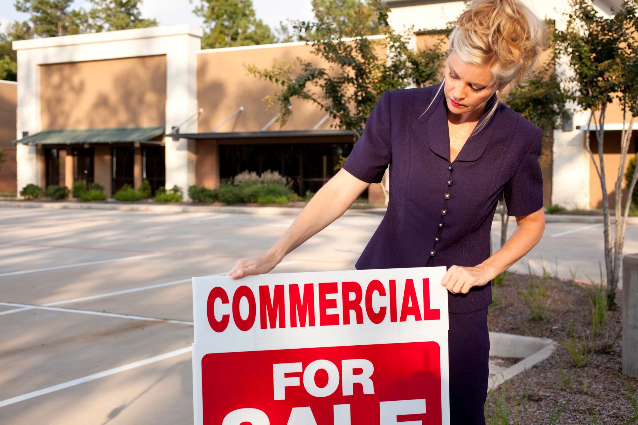 Real estate agent posting a sign for a commercial property.