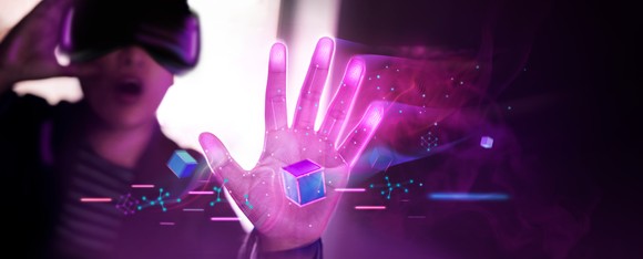 A person grabbing a virtual object while wearing a virtual reality headset.