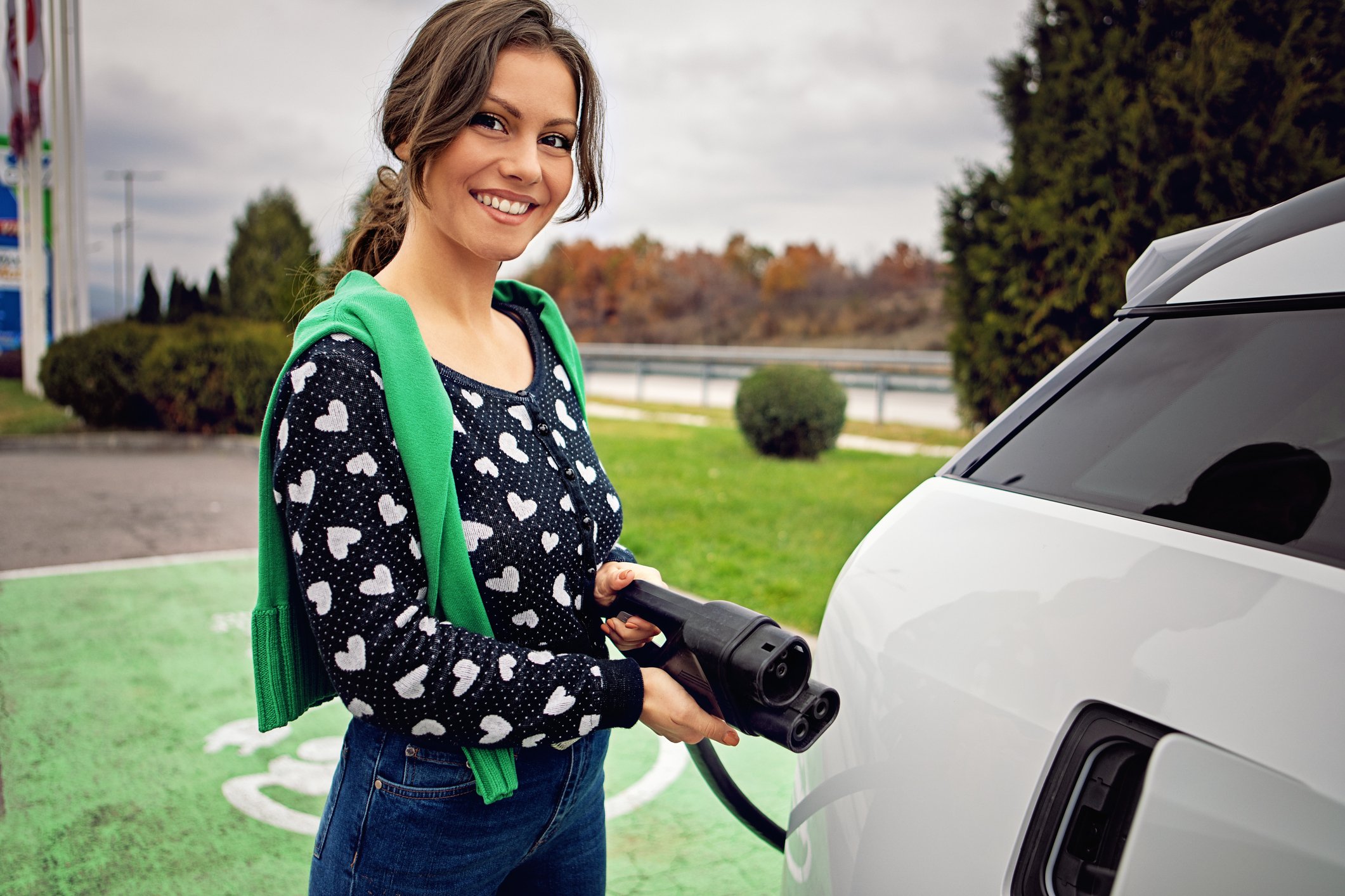 A person charging an electric car. 