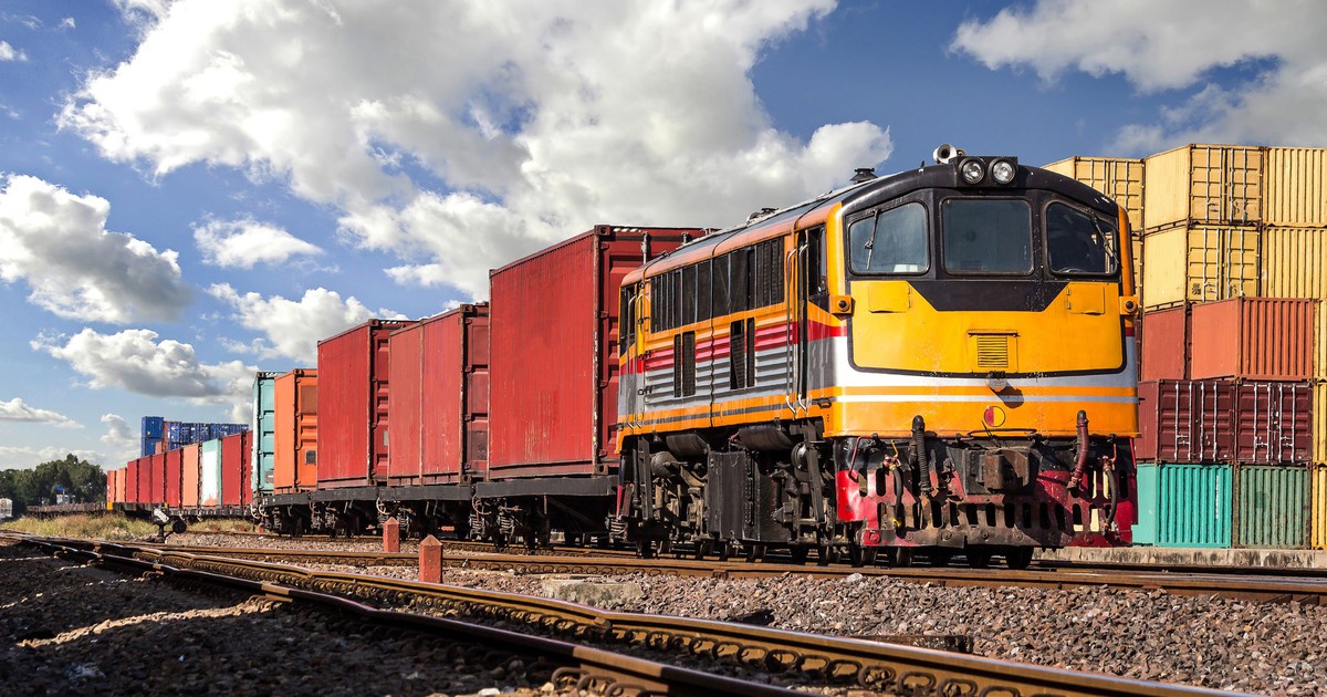 Train on a track with containers nearby.