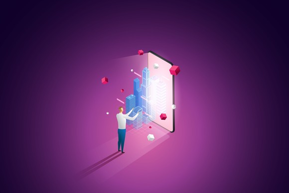 A person builds a building in the metaverse while standing in front of a phone.