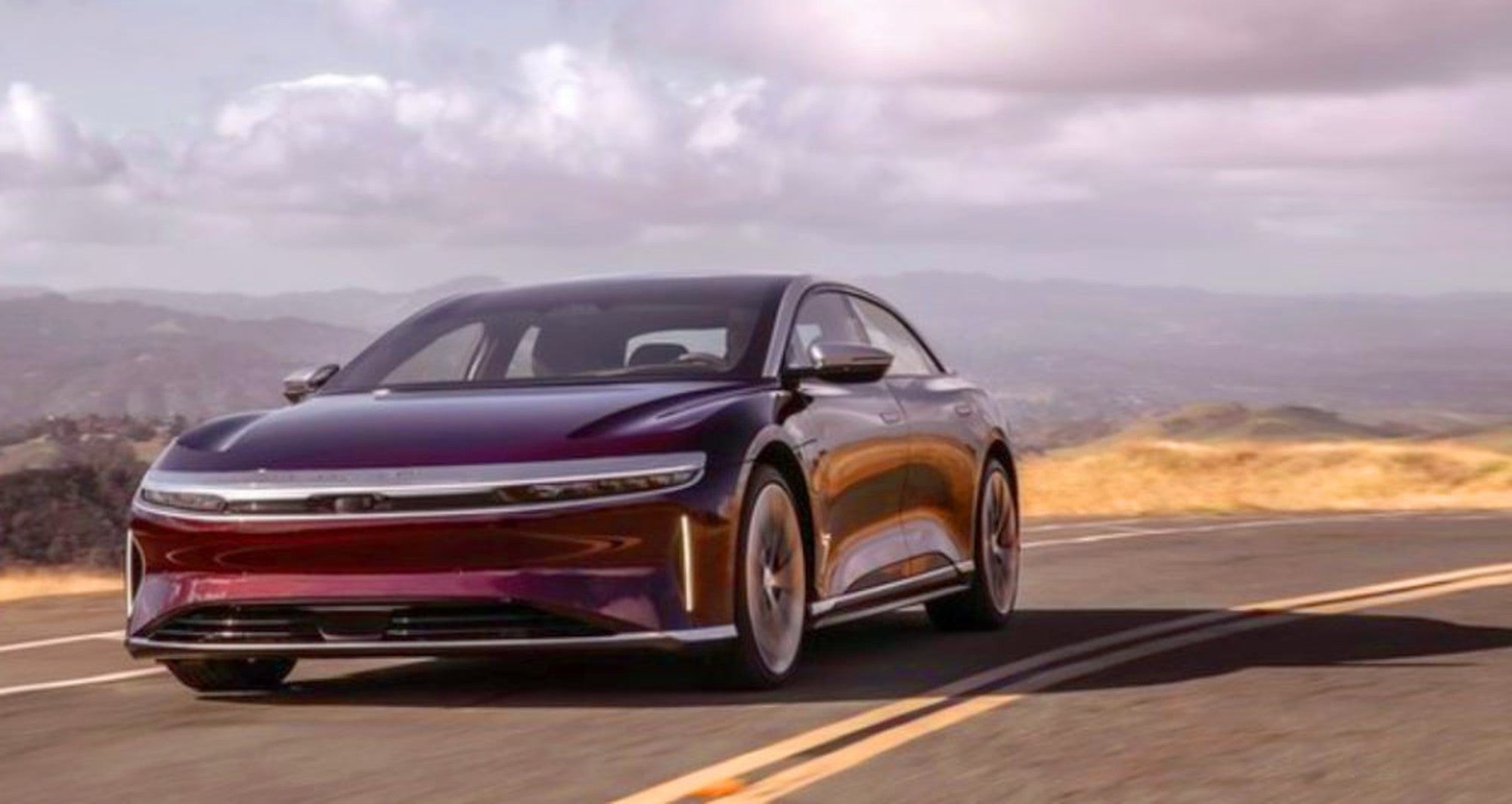 A Lucid Air luxury electric sedan cruises down an open road. 