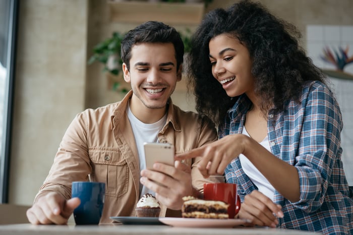 Two people looking at a smartphone.