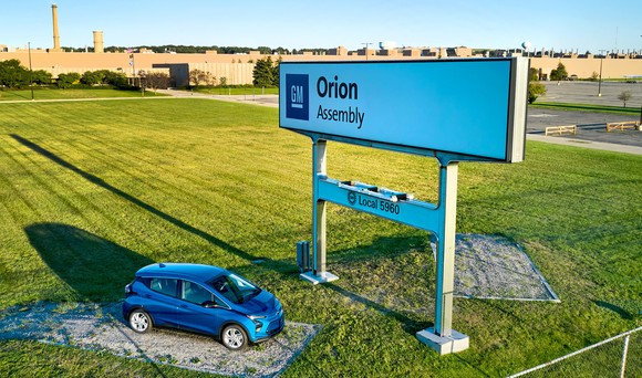 A sign, and a Chevrolet Bolt, in front of GM's Orion Assembly Plant in Lake Orion, Michigan. 