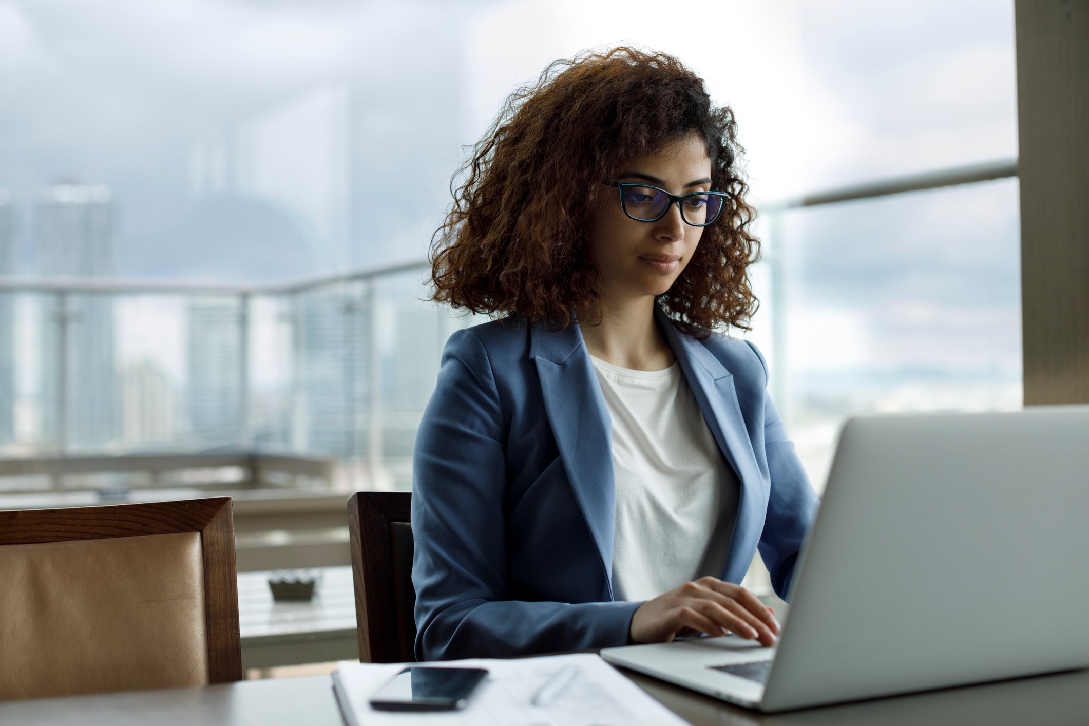 A person in business attire working on a computer.