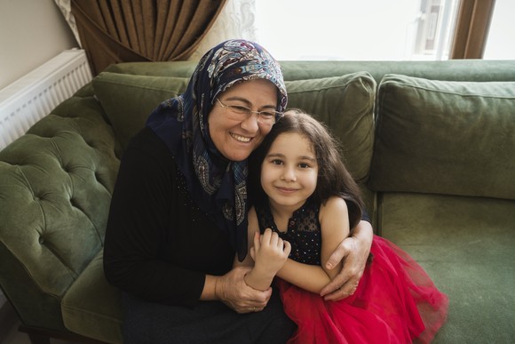 Child hugging older person.