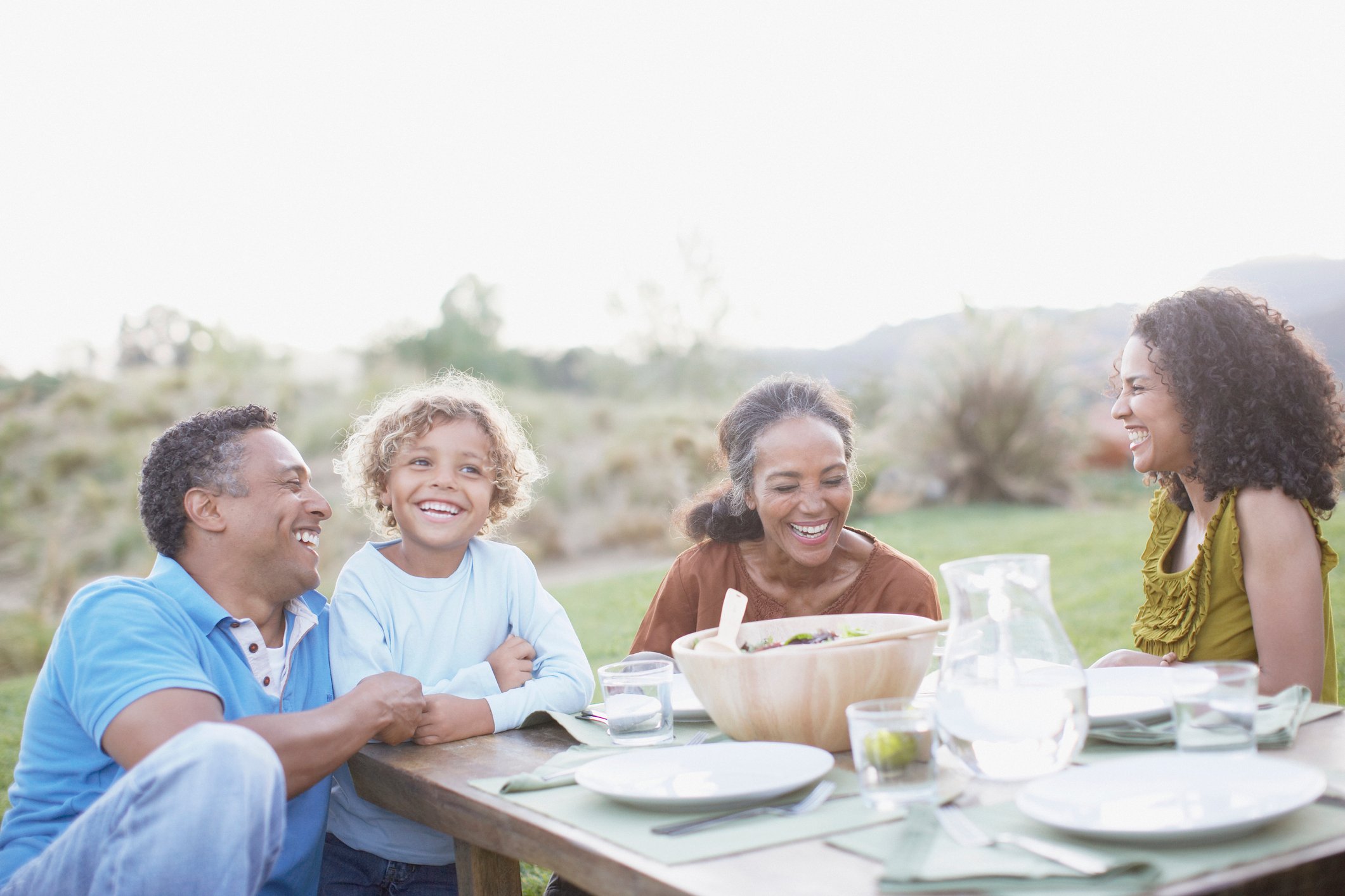 Group of young and old people dining outdoors.