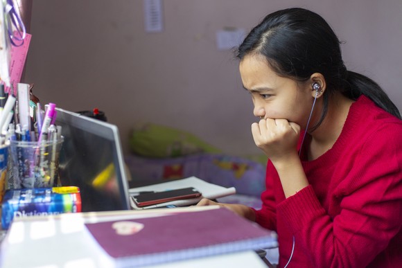 Young person looking at a laptop screen.