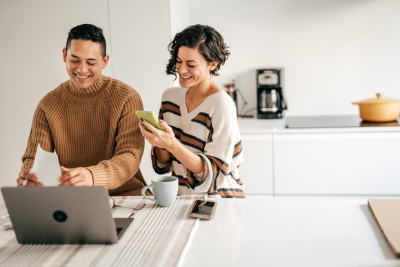 A couple looking at stocks on their devices at home.