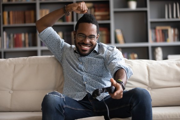 Gamer cheers while holding a game controller.