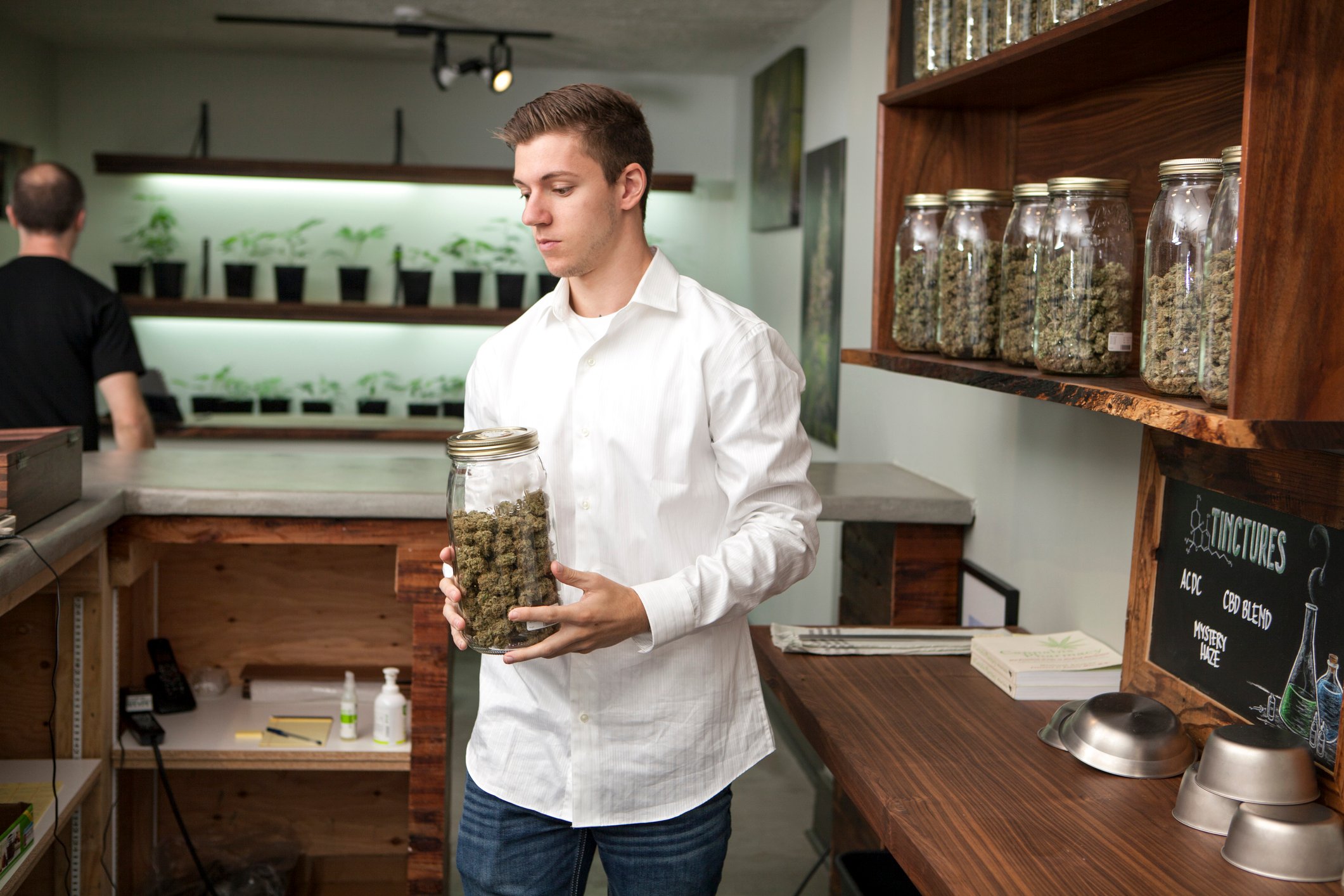 Person holding cannabis jar in cannabis store. 