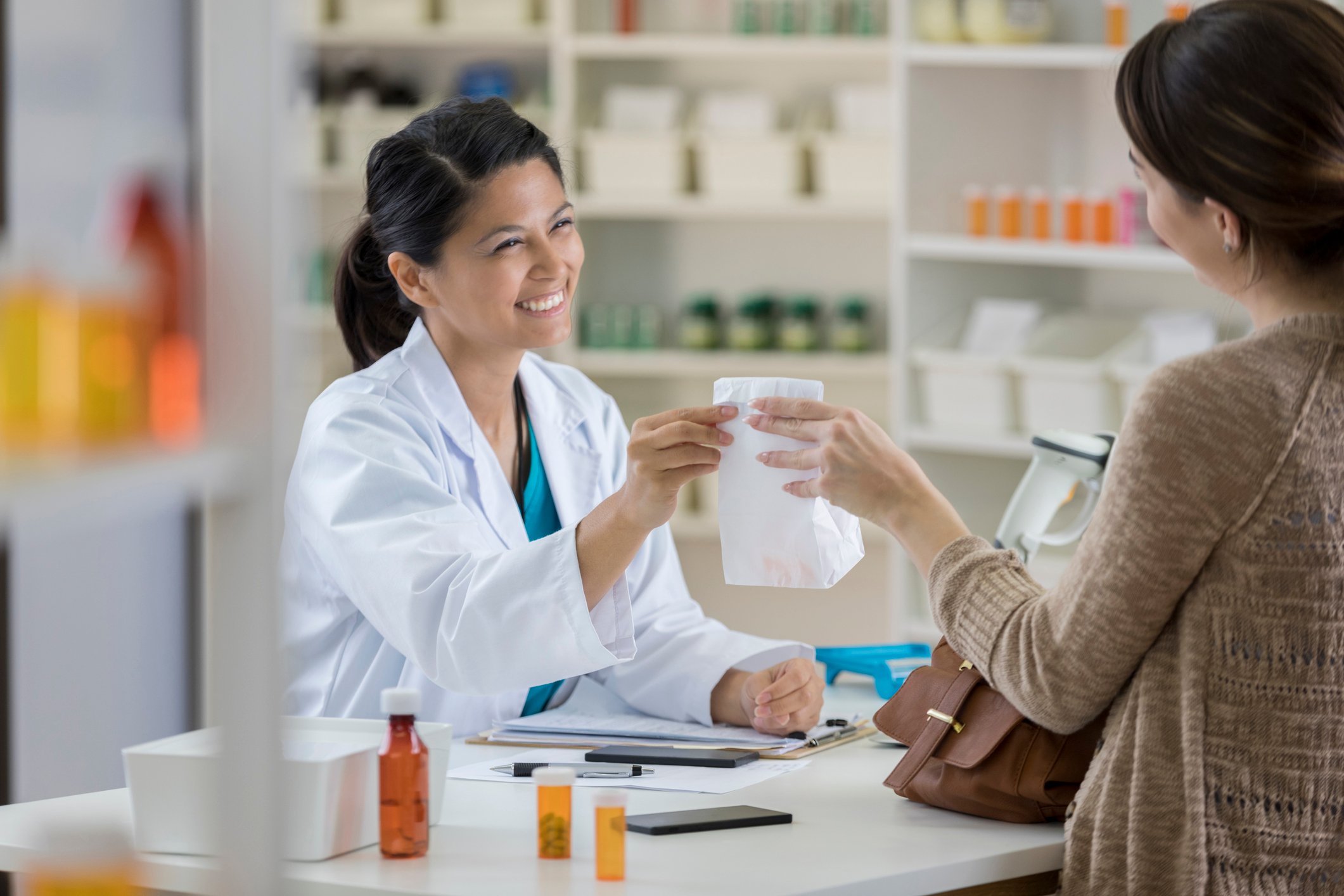 Pharmacist handing medicines to patient.