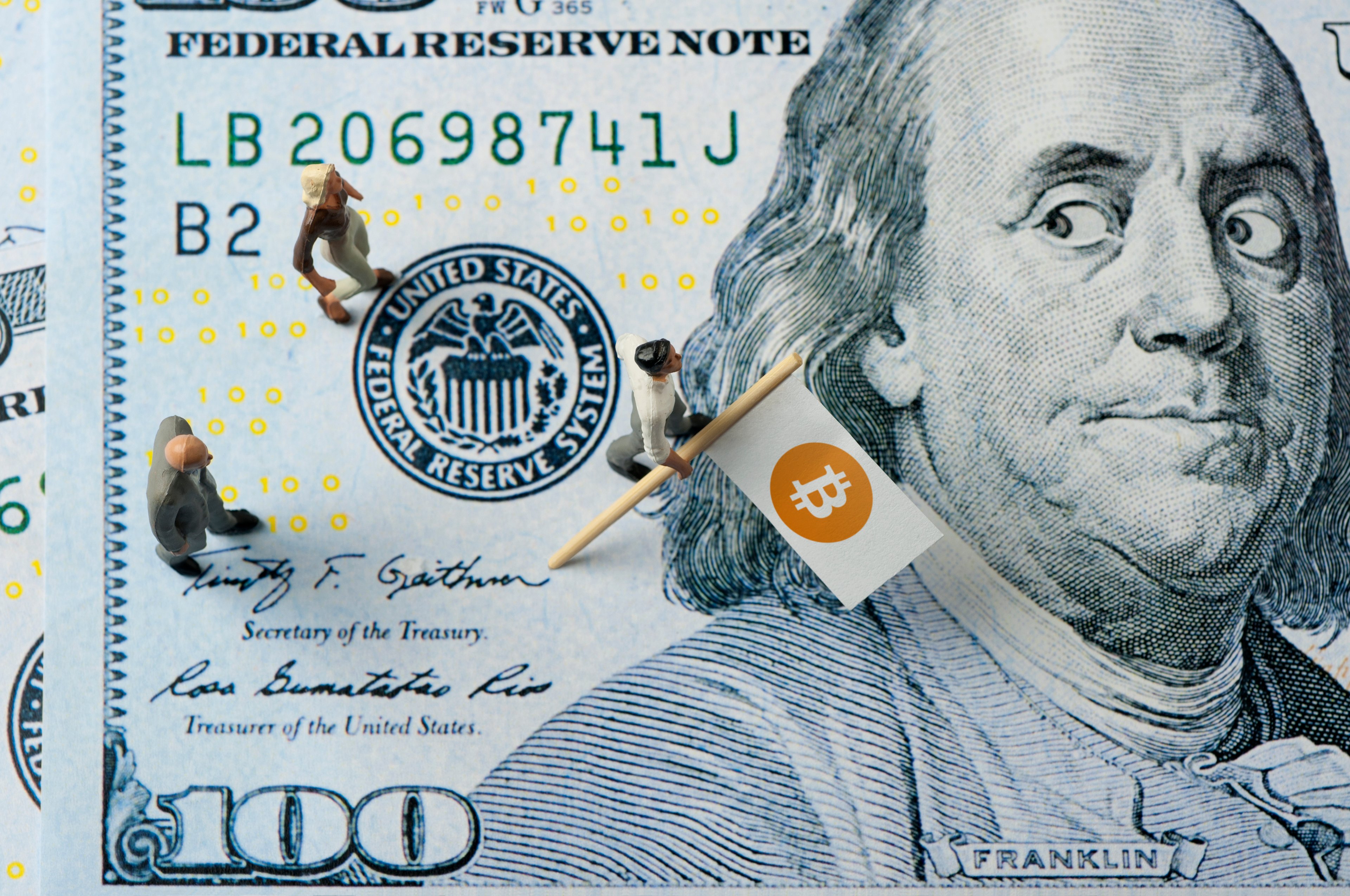 Benjamin Franklin on a $100 bill looking skeptically at Bitcoin.