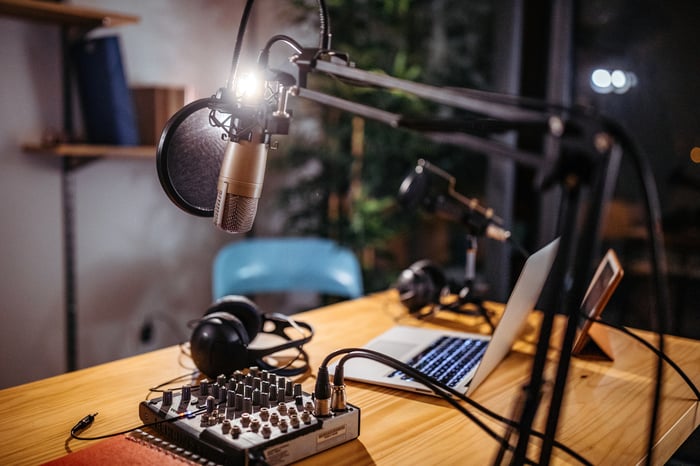 A home podcast studio with mic, mixer, and laptop.